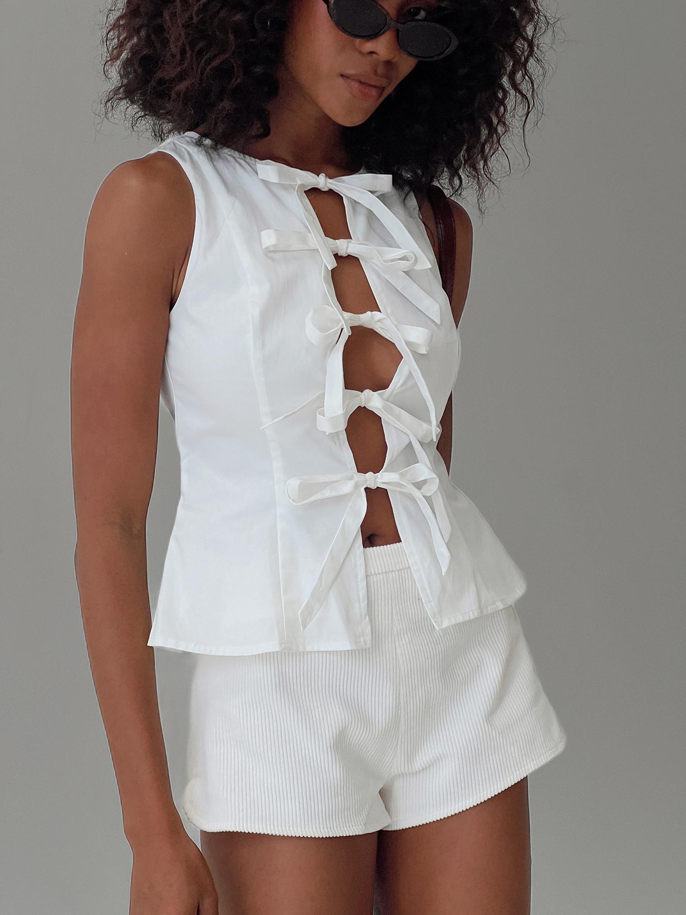 side view of model wearing Princess Polly Luminary Tie Up Top White Sleeveless Crew Neck 