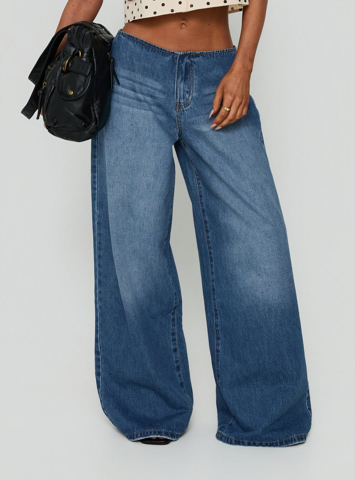 Showcasing the Roamer No Waist Low Rise Super Baggy Vintage Mid Blue womens jeans with low-rise waist front view of model wearing Princess Polly