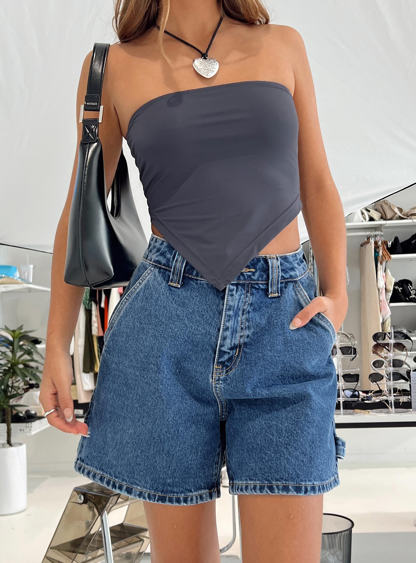back view of model wearing Princess Polly Lou Carpenter Denim Shorts Mid Wash Petite High Waisted Shorts 
