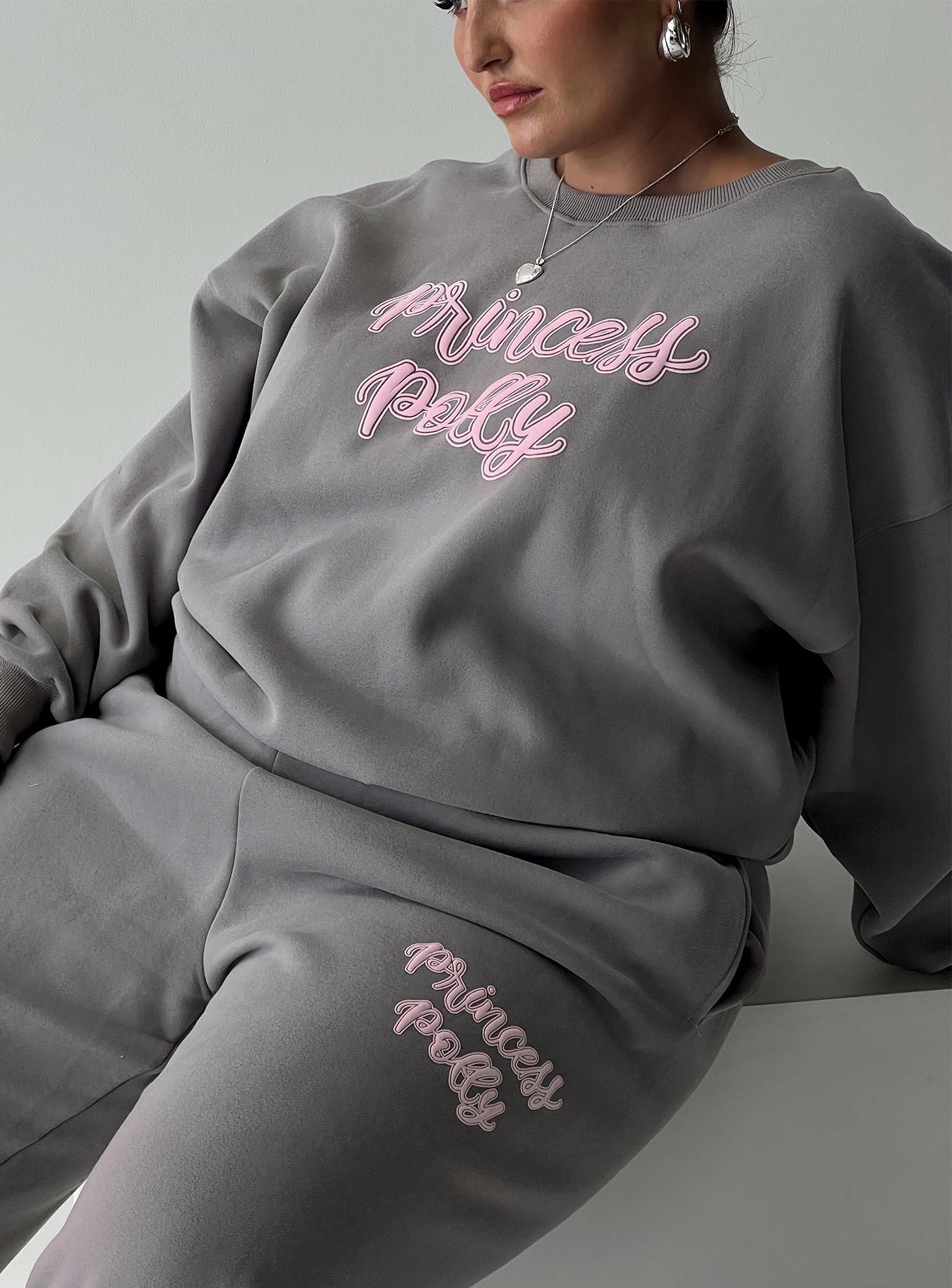 back view of model wearing Princess Polly Princess Polly Crew Neck Sweatshirt Puff Text Charcoal Curve 