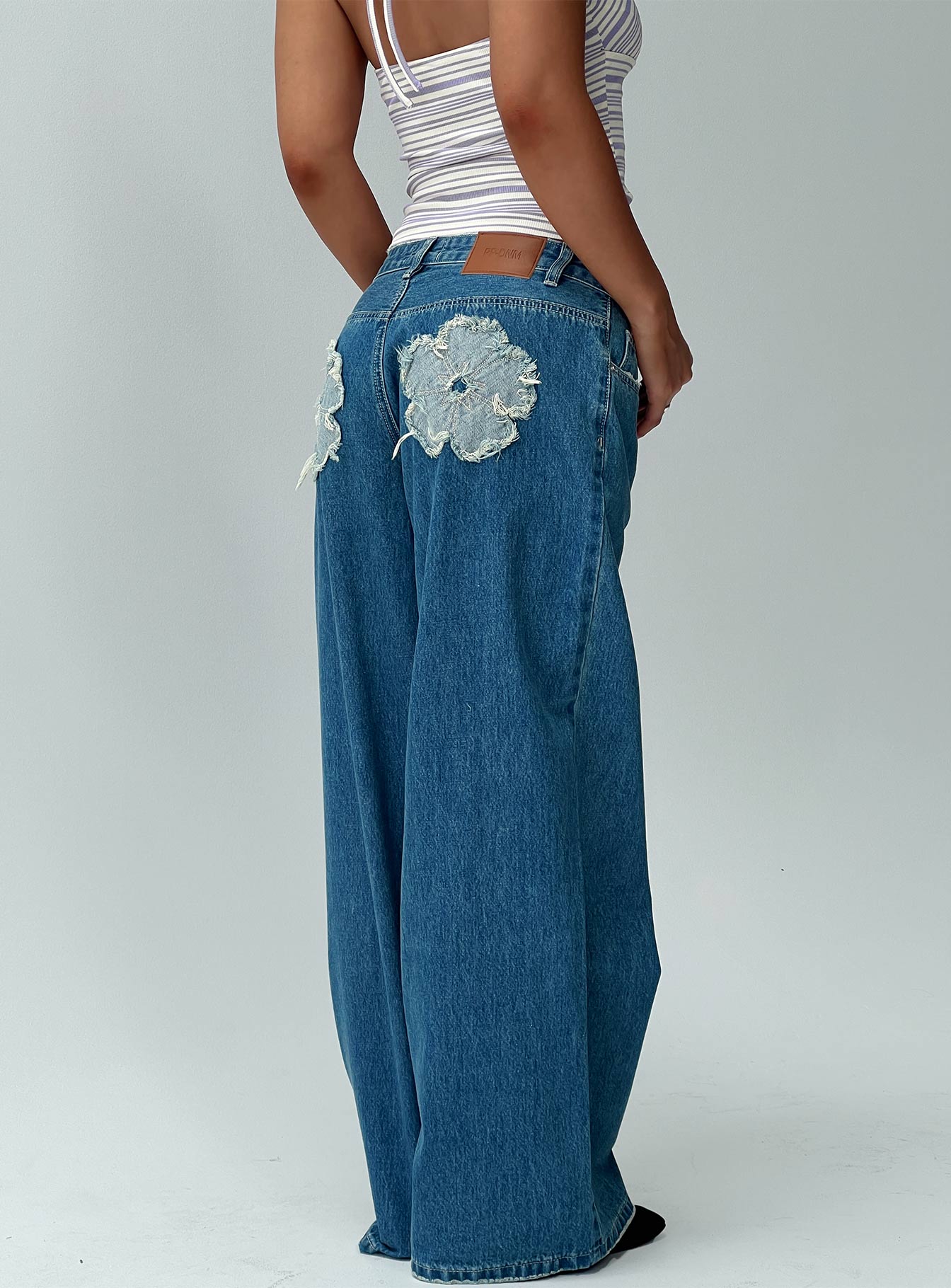 back view of model wearing Princess Polly A Keeper Flower Patch Jeans Mid Blue Low Rise Jeans 