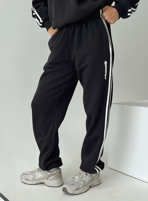 side view of model wearing Princess Polly Princess Polly Track Pants Stripe Black / White High Waisted Pants 