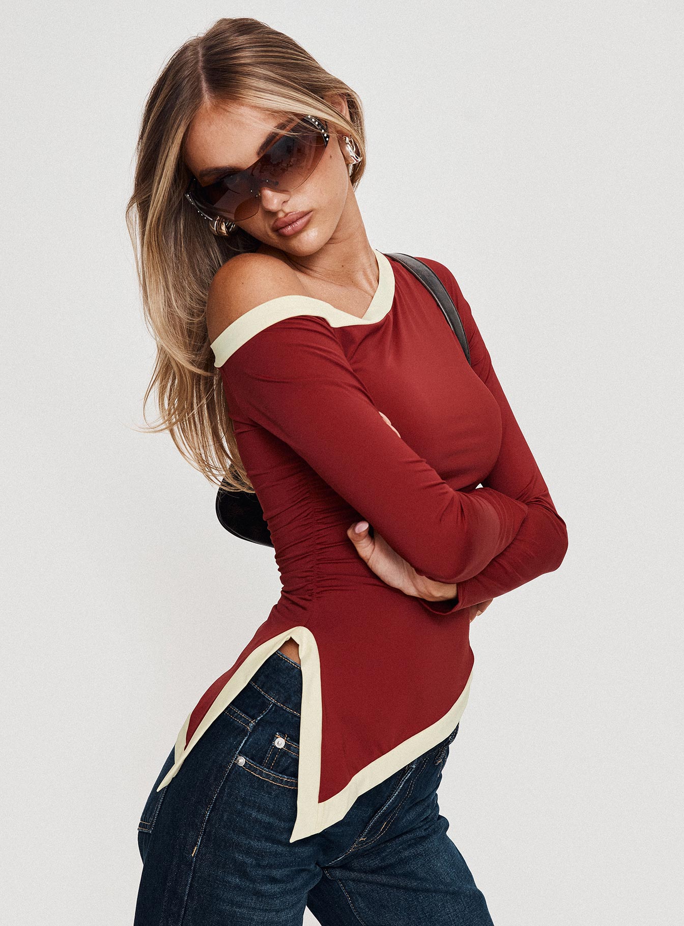 side view of model wearing Princess Polly Fake Smile Long Sleeve Top Burgundy / Cream Full Sleeves Asymmetric Neckline 