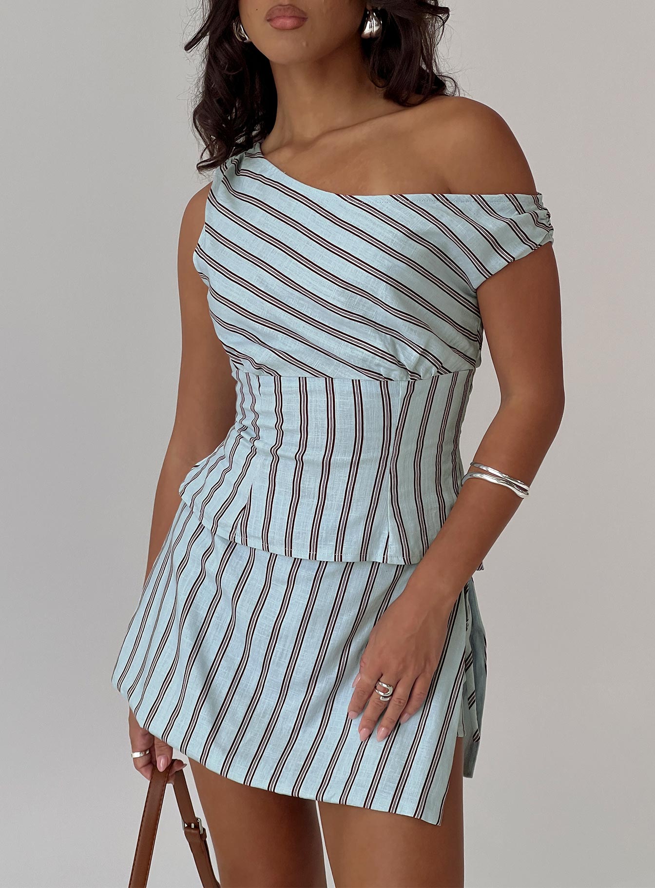 side view of model wearing Princess Polly Gulliver Tie Side Mini Skort Blue / Maroon Stripe High Waisted Shorts 