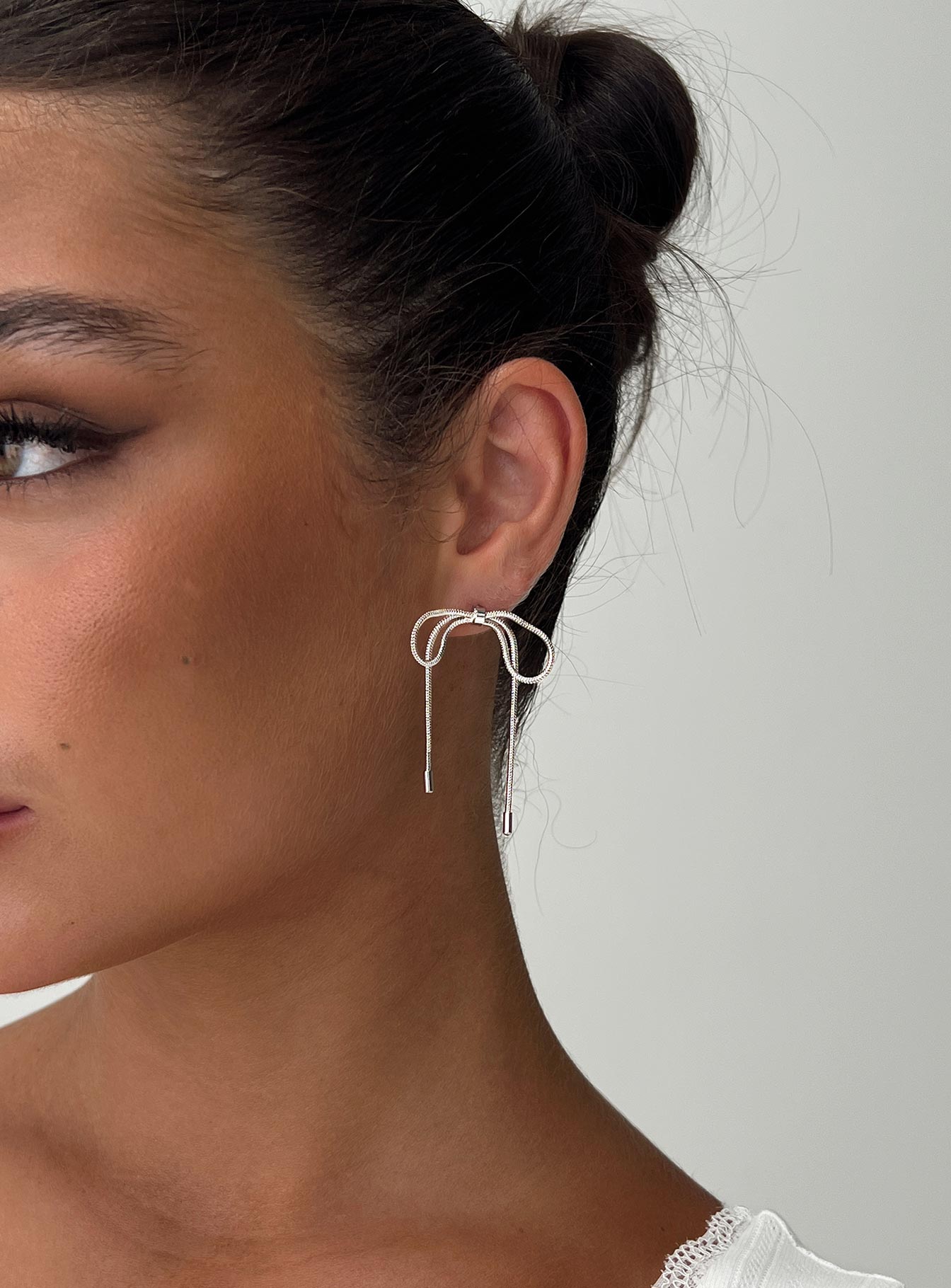 Silver-toned earrings Bow design, stud fastening