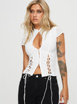 Top Sheer material, mandarin collar with button fastening, cap sleeves, four splits at hem front and back with lace-up fastening, cut-out detail at bust, hook & eye fastening down front