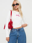 side view of model wearing Princess Polly Bow Baby Long Sleeve Top White Full Sleeves Full Sleeves Crew Neck Crew Neck 