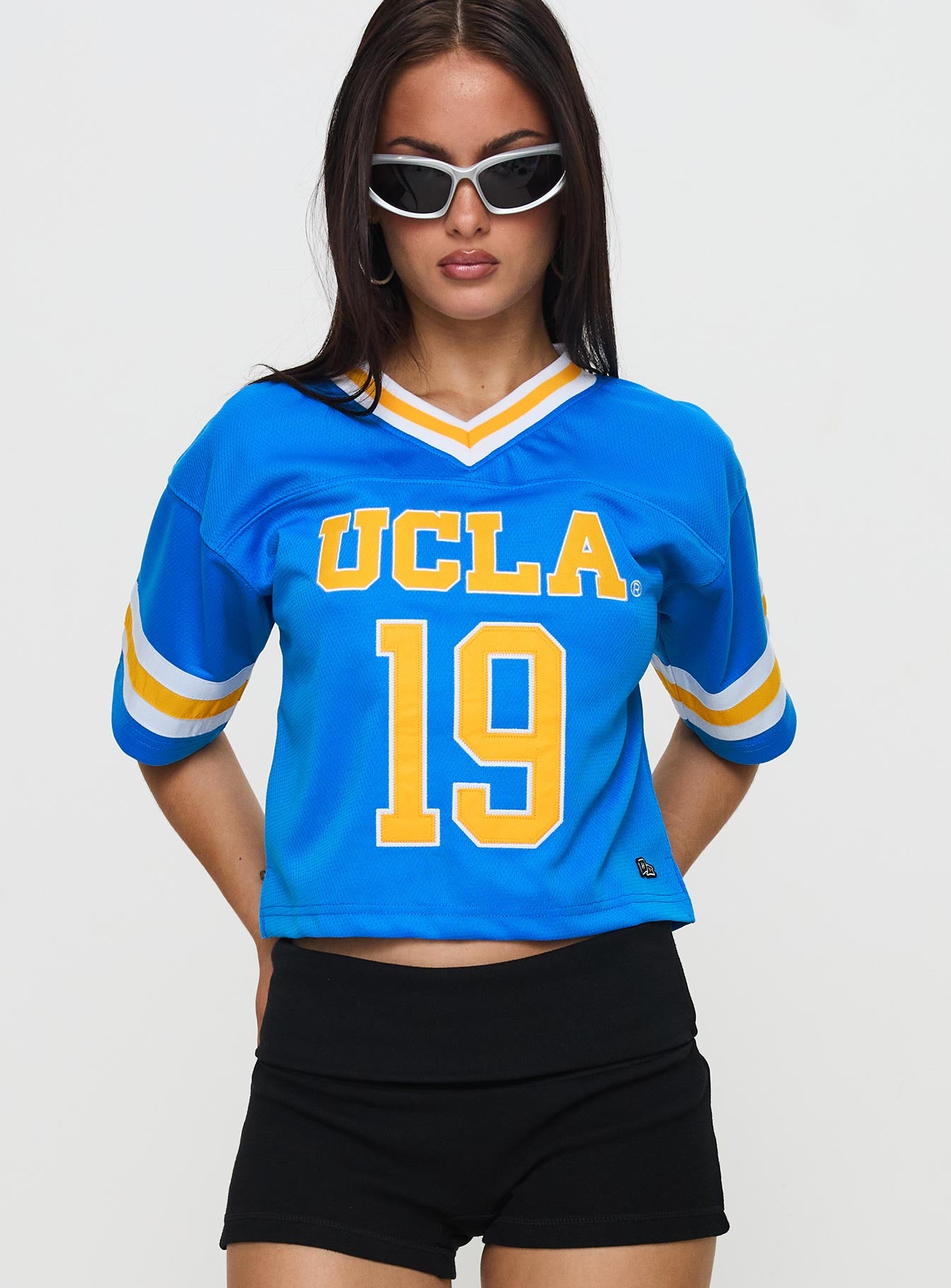 front view of model wearing Princess Polly UCLA Football Jersey Blue Half Sleeves V-Neck 