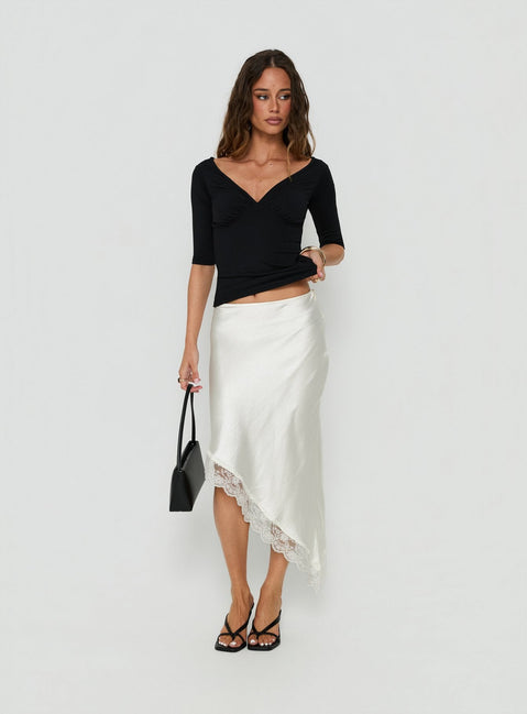 Featuring the Koletta Asymmetrical Lace Trim Satin Midi Skirt in Ivory with fitted silhouette front view of model wearing Princess Polly