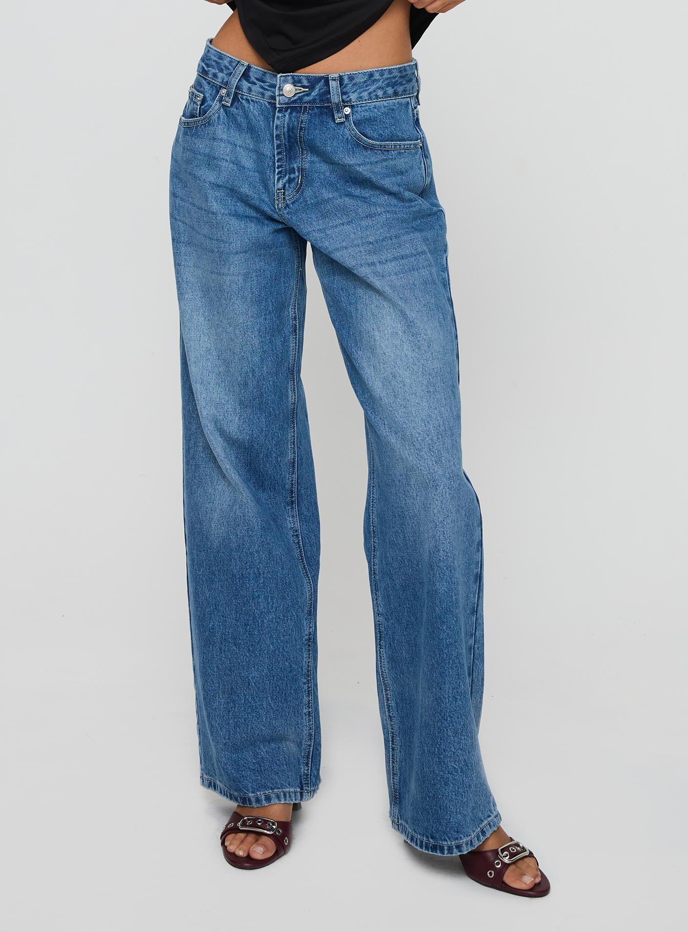 side view of model wearing Princess Polly Serenitia Mid Rise Relaxed Jeans Mid Blue Wash Petite Mid Rise 