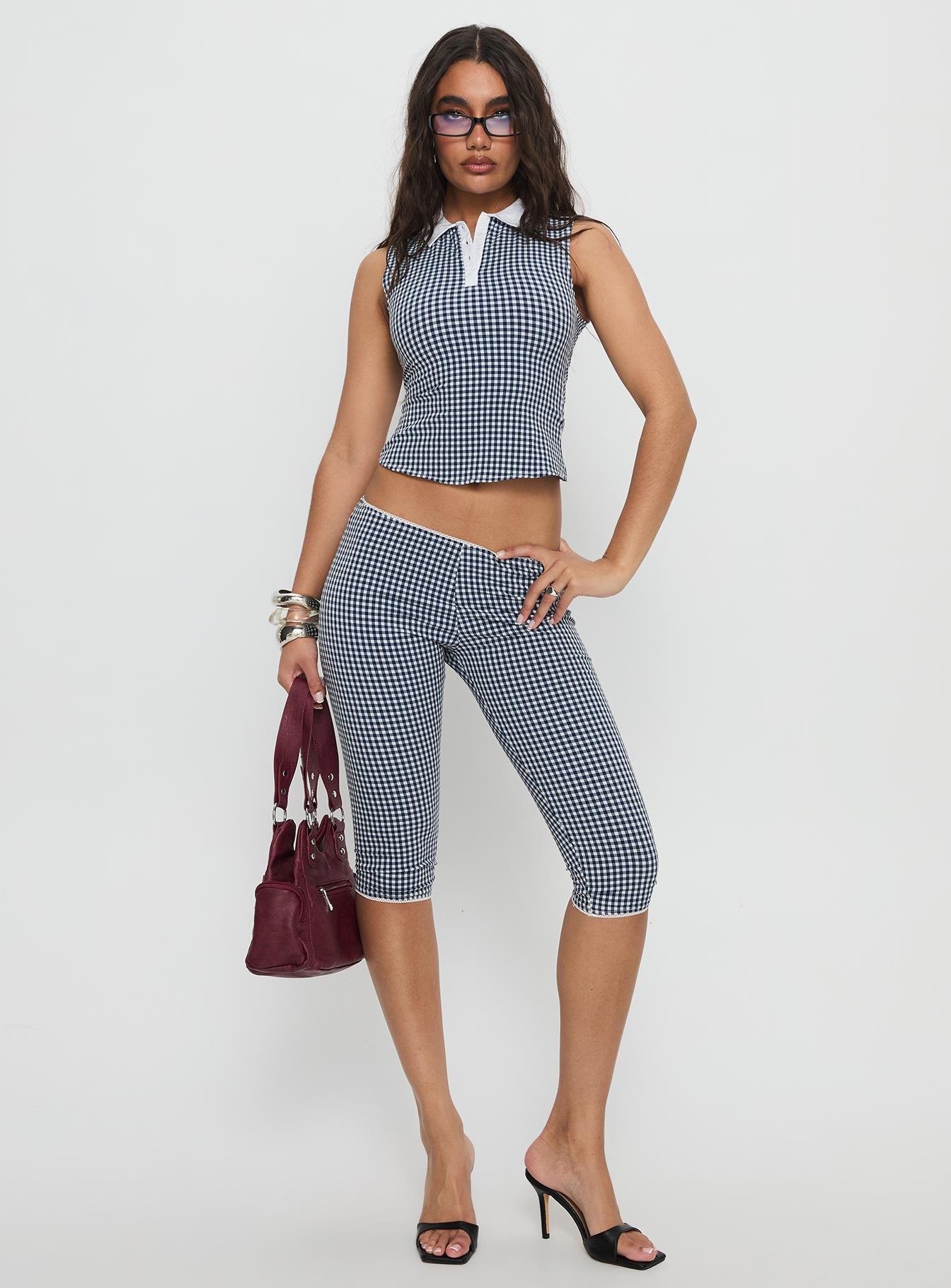 side view of model wearing Princess Polly Tuka Capri Navy Gingham Mid Rise Pants 