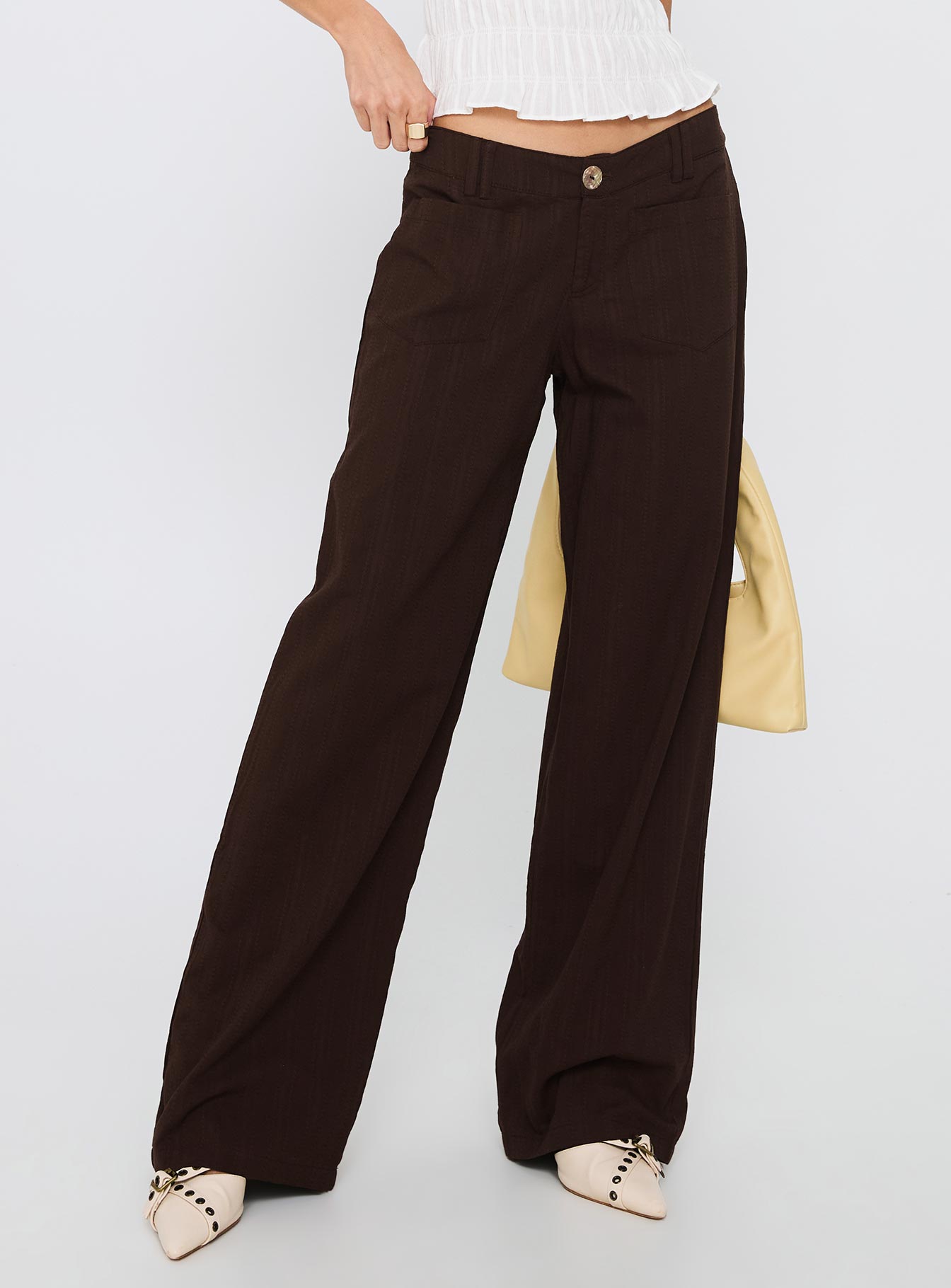 side view of model wearing Princess Polly Vendi Low Rise Pant Chocolate Low Rise Pants 