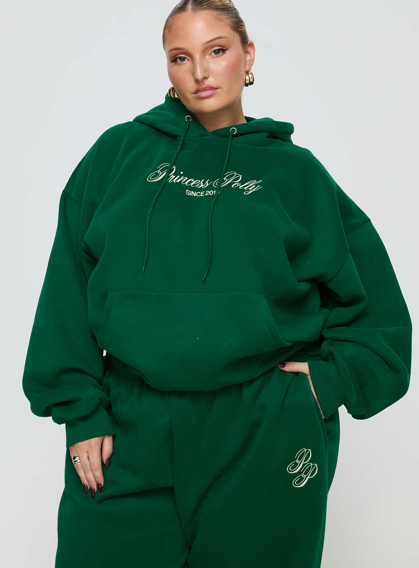front view of model wearing Princess Polly Princess Polly Hooded Sweatshirt Script Green / Ivory Curve 