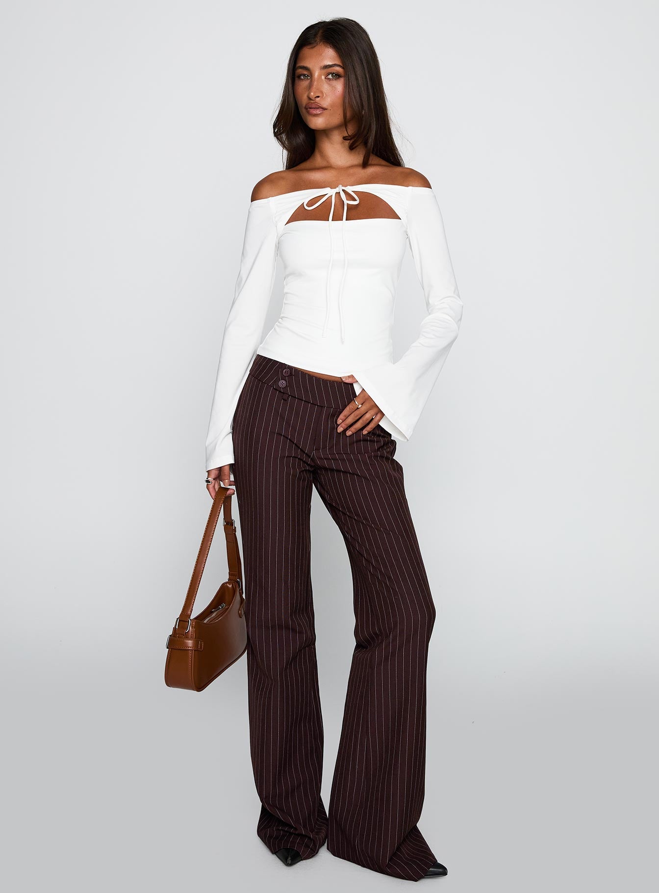 front view of model wearing Princess Polly Kinkirk Flared Pants Brown Pinstripe Low Rise Pants 