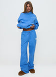 front view of model wearing Princess Polly Princess Polly Wide Leg Track Pant Bubble Text Blue High Waisted Pants 