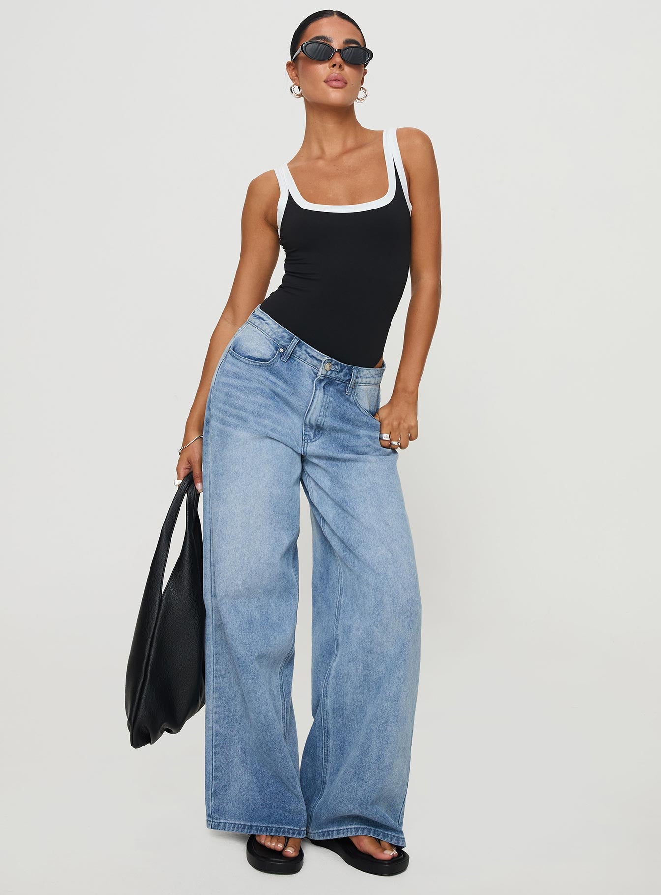 side view of model wearing Princess Polly Astrea Bodysuit Black / White Sleeveless 