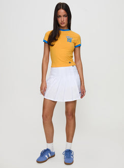   side view of model wearing Princess Polly UCLA Tennis Skort White 