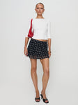   side view of model wearing Princess Polly Dapple Bias Mini Skirt Black Polka Dot Mini Skirts 