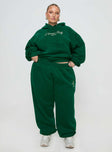 front view of model wearing Princess Polly Princess Polly Track Pants Script Green / Ivory Curve High Waisted Pants 