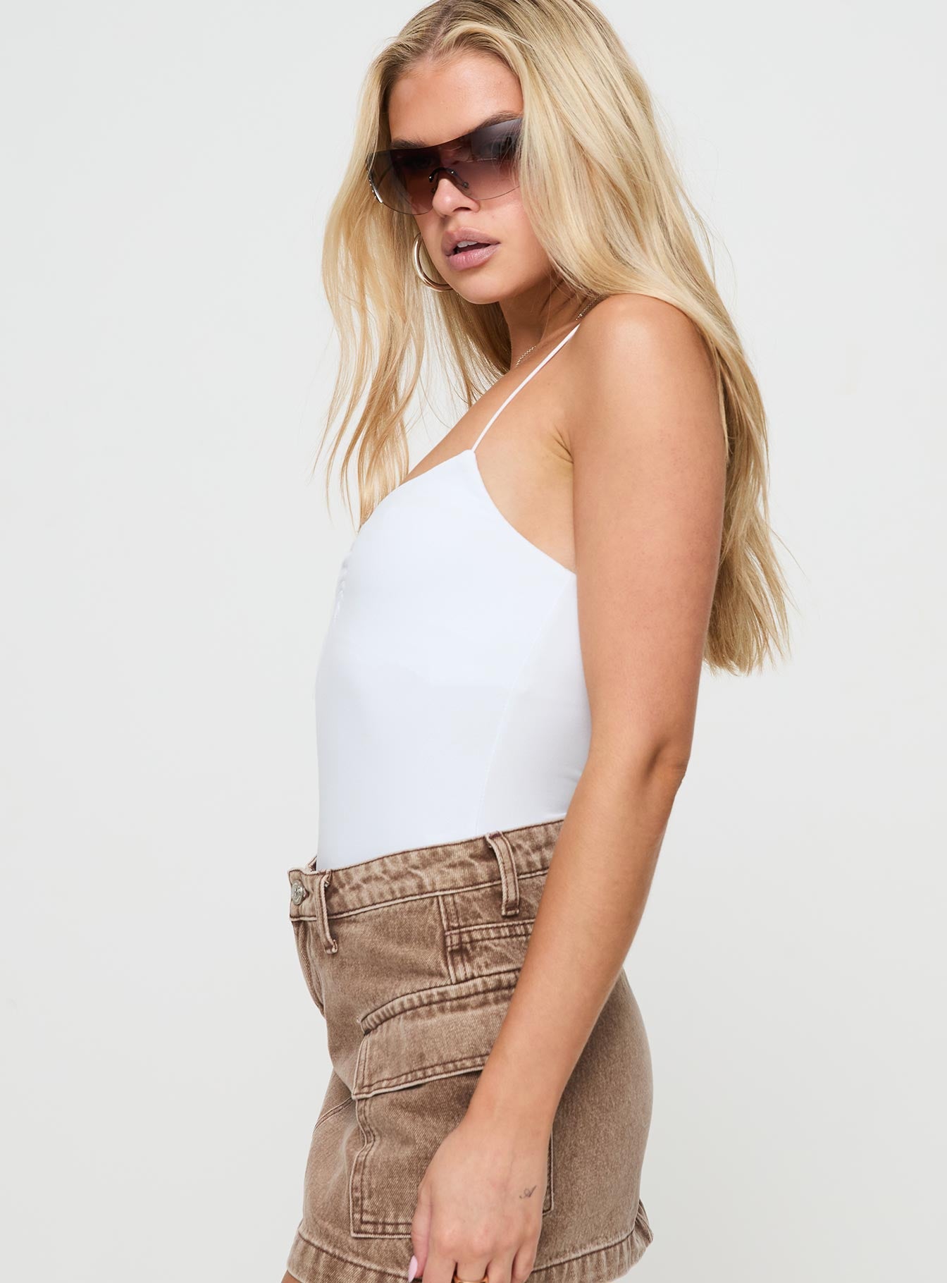 side view of model wearing Princess Polly Bekks Bodysuit White Sleeveless V-Neck 