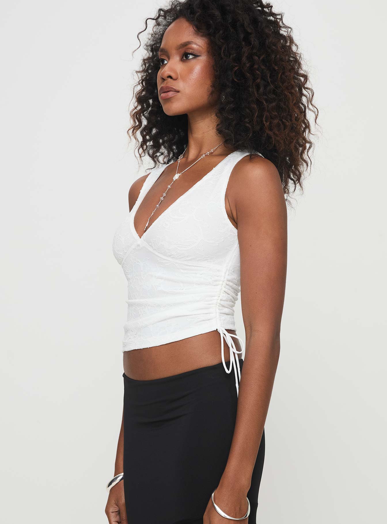 side view of model wearing Princess Polly Truth Top White Sleeveless V-Neck 