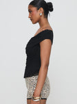 side view of model wearing Princess Polly Sonnie Off Shoulder Top Black Short Sleeves Cowl 