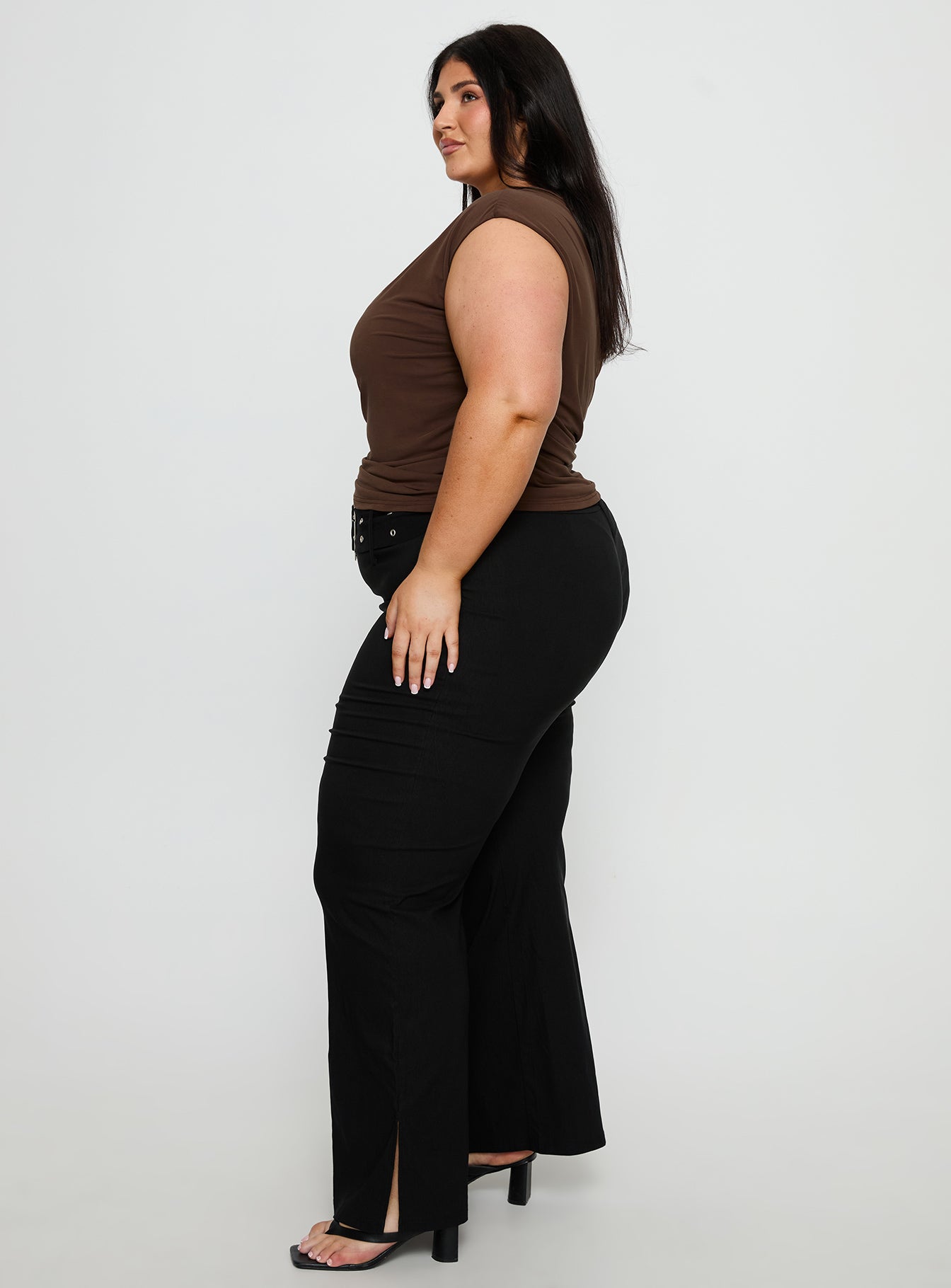 side view of model wearing Princess Polly Kortnee Eyelet Detail Flare Leg Pants Black Curve Mid Rise Pants 