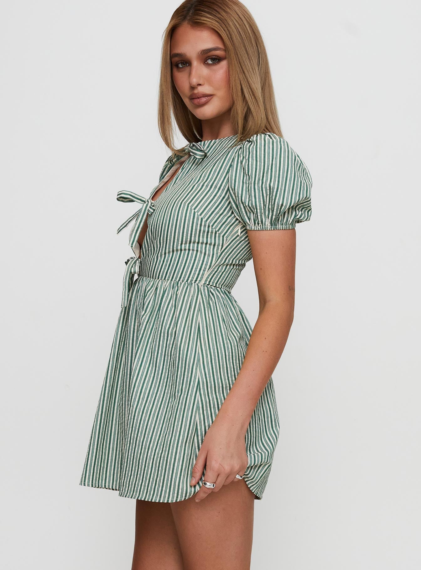 side view of model wearing Princess Polly Nurture Bow Mini Dress Green Stripe Crew Neck 