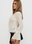 side view of model wearing Princess Polly Sainz Frill Long Sleeve Top Cream Full Sleeves V-Neck 