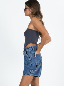 side view of model wearing Princess Polly Lou Carpenter Denim Shorts Mid Wash Petite High Waisted Shorts 