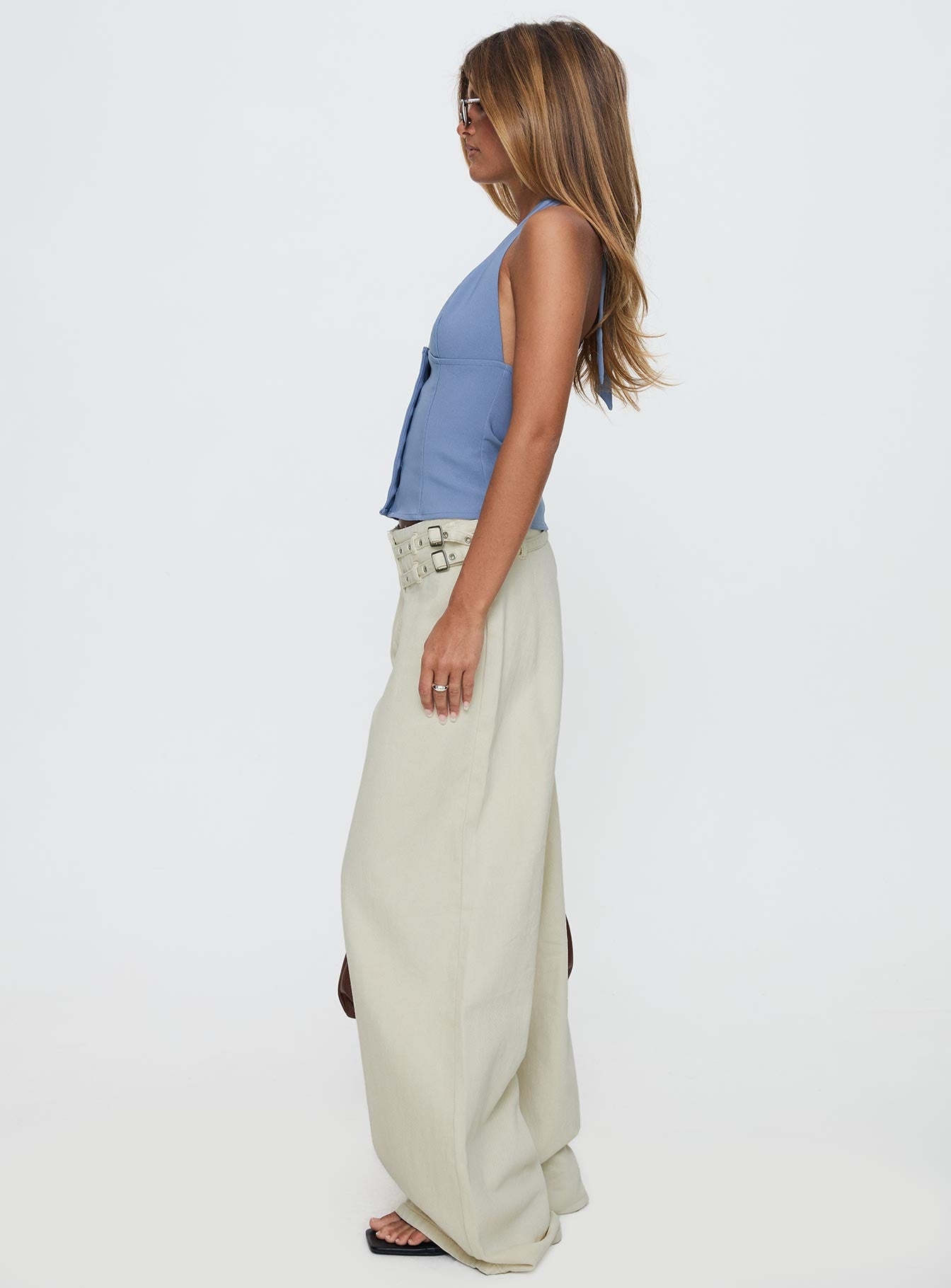 side view of model wearing Princess Polly Paltrow Mid Rise Wide Leg Cargo Jeans Cream Petite Low Rise Jeans 