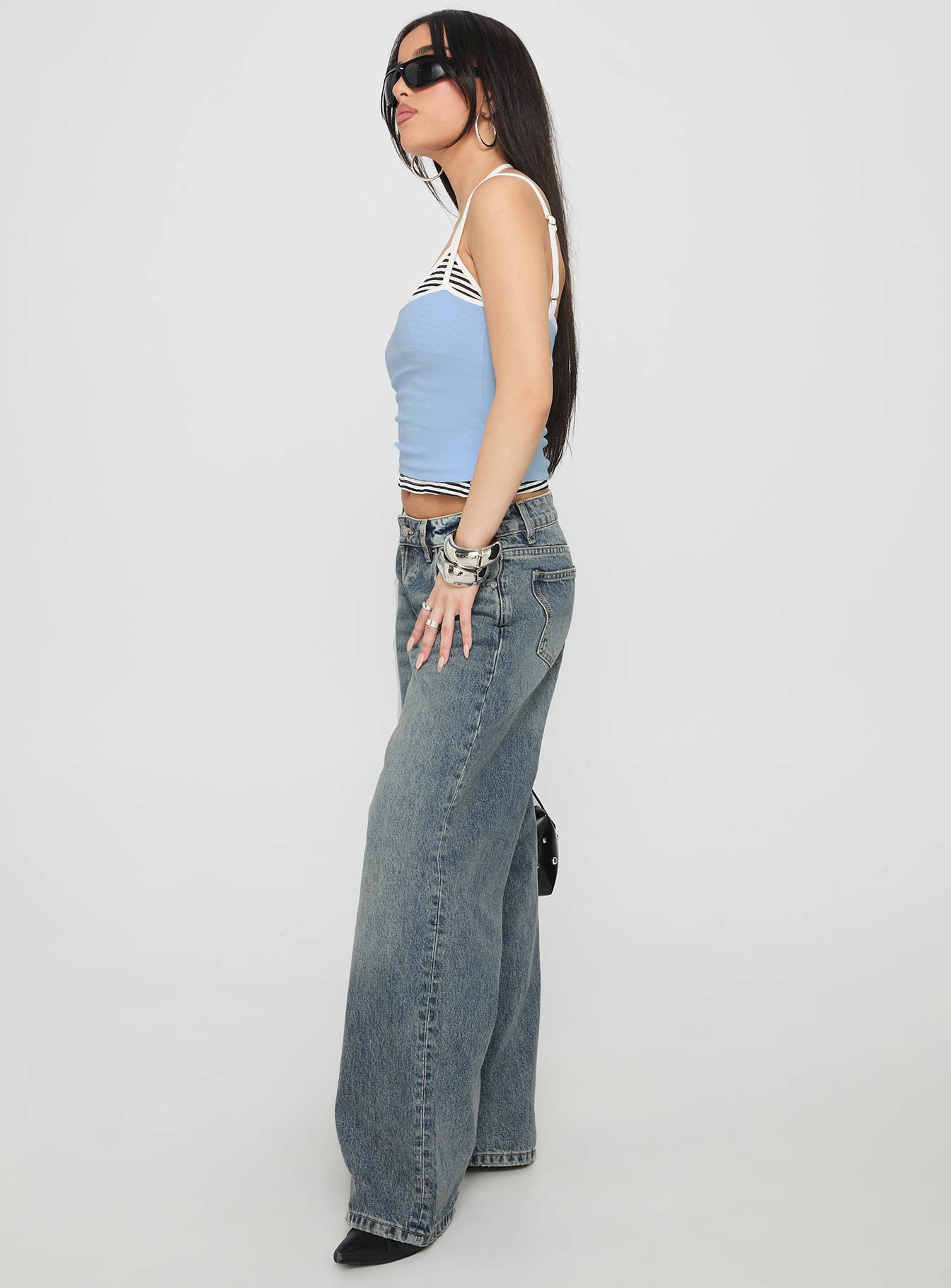side view of model wearing Princess Polly Zaralyn Low Rise Wide Leg Jeans Mid Blue Wash Low Rise Jeans 