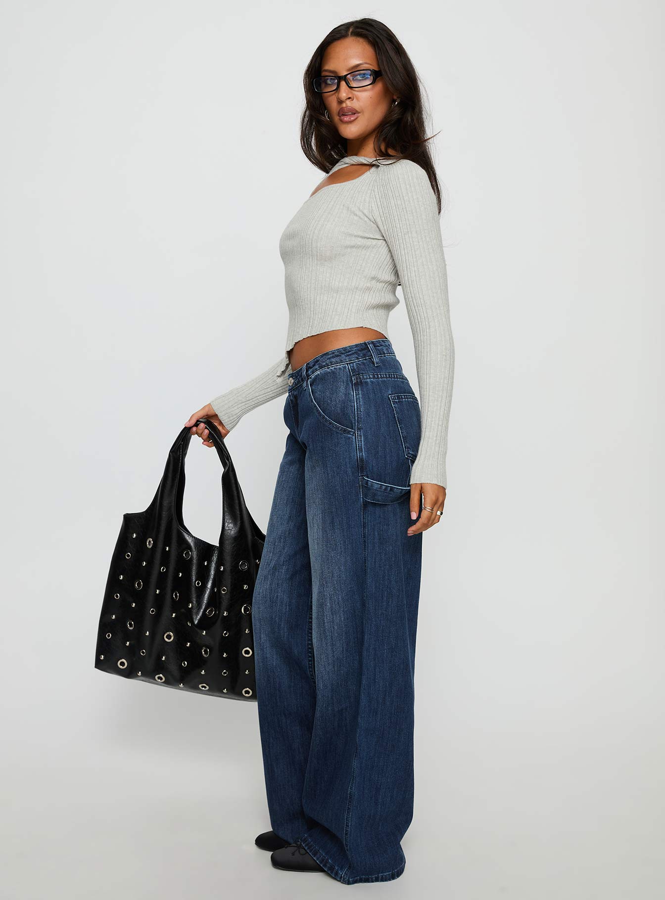 side view of model wearing Princess Polly Downtowner Low Rise Cargo Jeans Mid Blue Wash Low Rise Jeans 