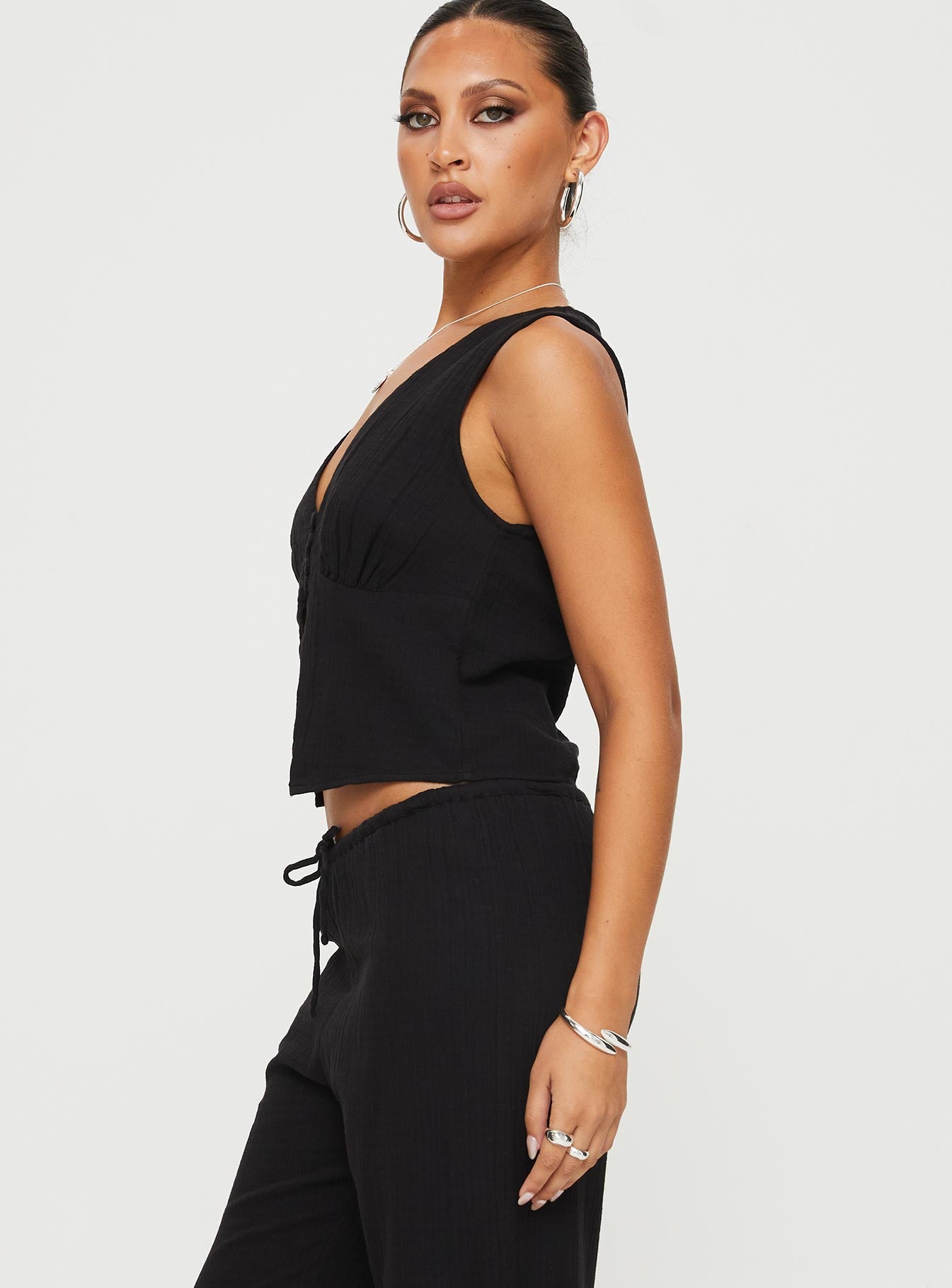 side view of model wearing Princess Polly Momo Vest Top Black Sleeveless Plunger 