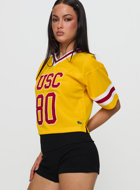 side view of model wearing Princess Polly USC Football Jersey Gold Half Sleeves V-Neck 