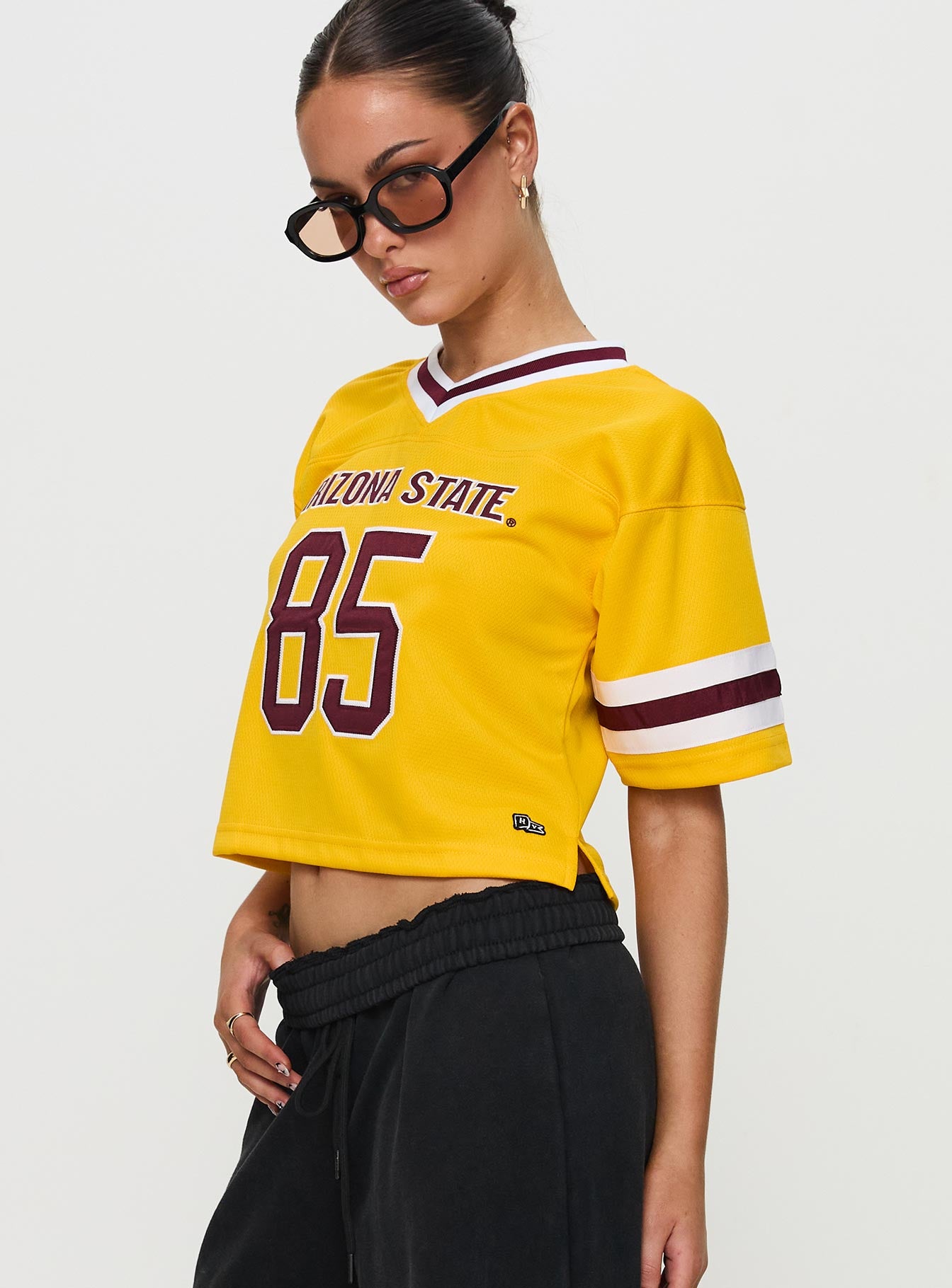side view of model wearing Princess Polly ASU Football Jersey Gold Half Sleeves V-Neck 