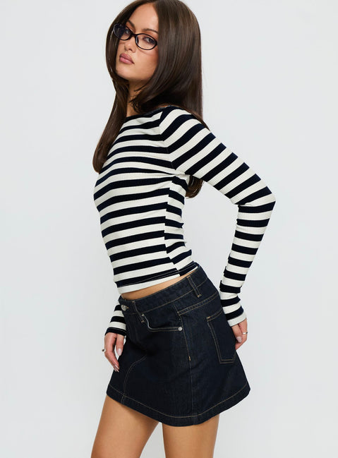   side view of model wearing Princess Polly Nickei Denim Mini Skirt Raw Dark Wash Mini Skirts 