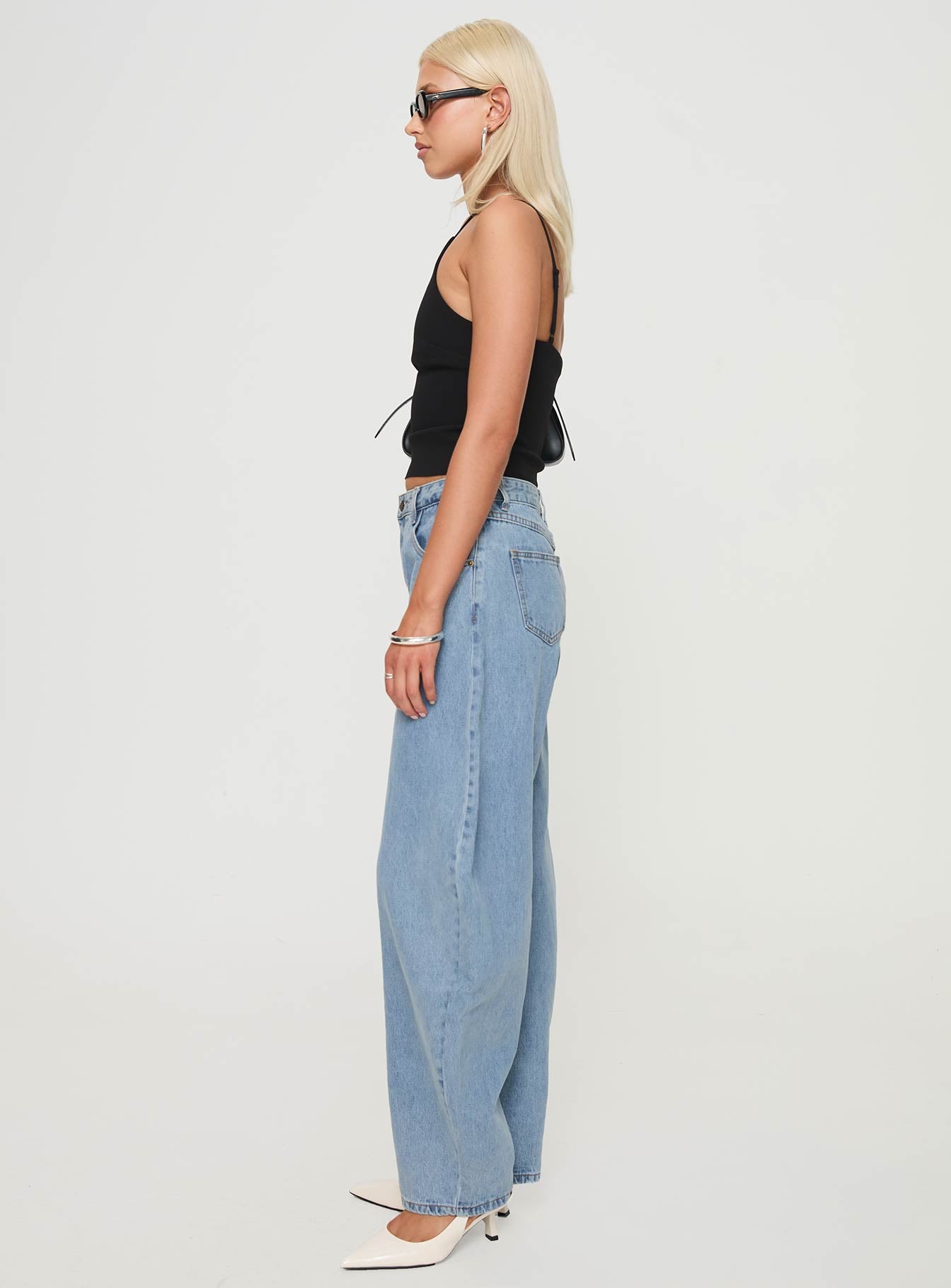 side view of model wearing Princess Polly Horseshoe Jeans Washed Blue High Waisted 