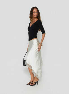 Crafted from satin, the Koletta Asymmetrical Lace Trim Midi Skirt in Ivory womens-skirts side view of model wearing Princess Polly