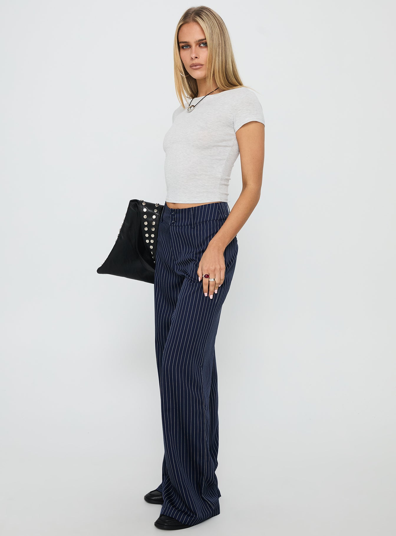 side view of model wearing Princess Polly Lorenne Mid Rise Pant Navy Pinstripe High Waisted Pants 