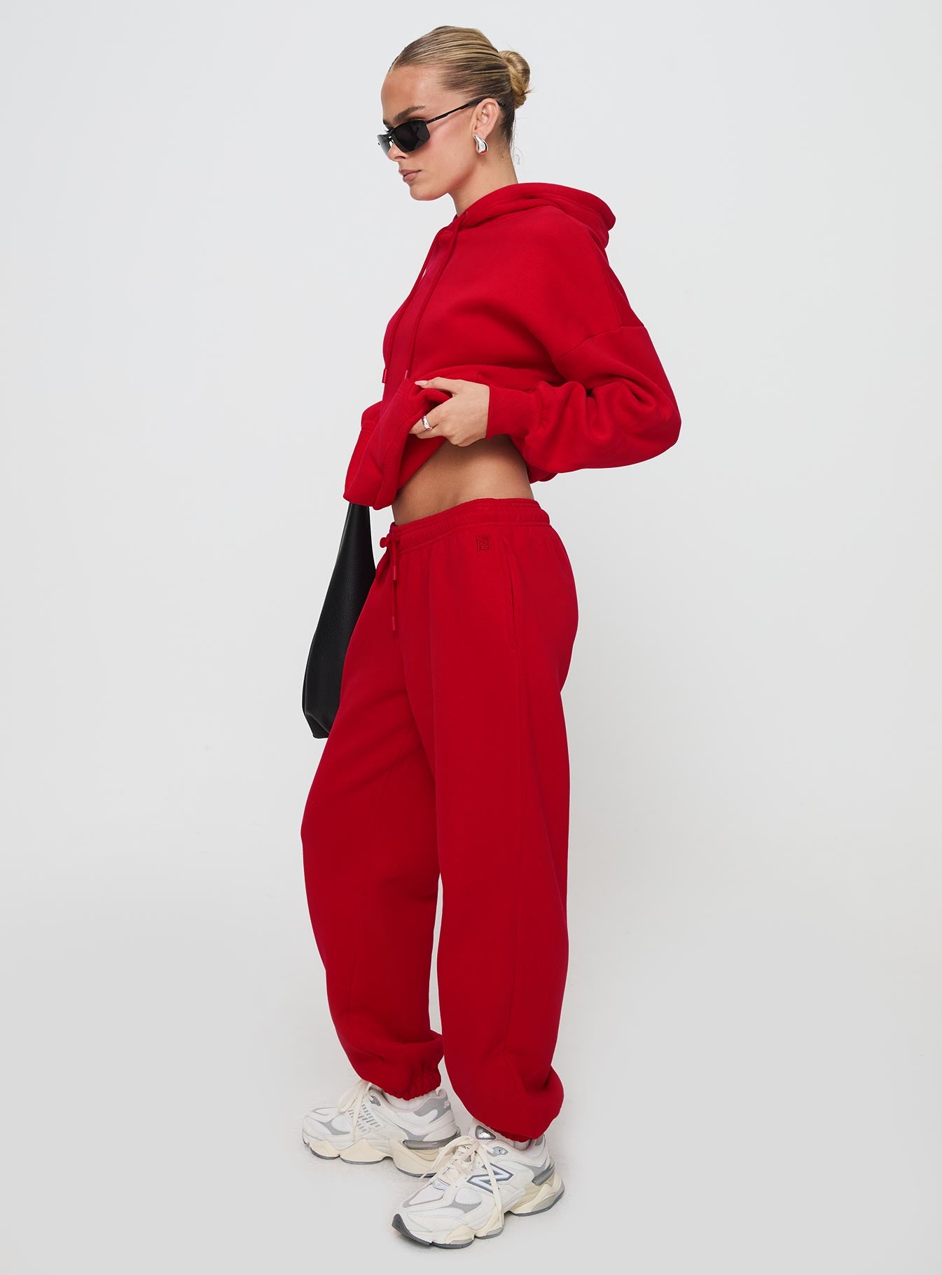 side view of model wearing Princess Polly Dream Fleece Ankle Cuff Sweatpants Red High Waisted Pants 