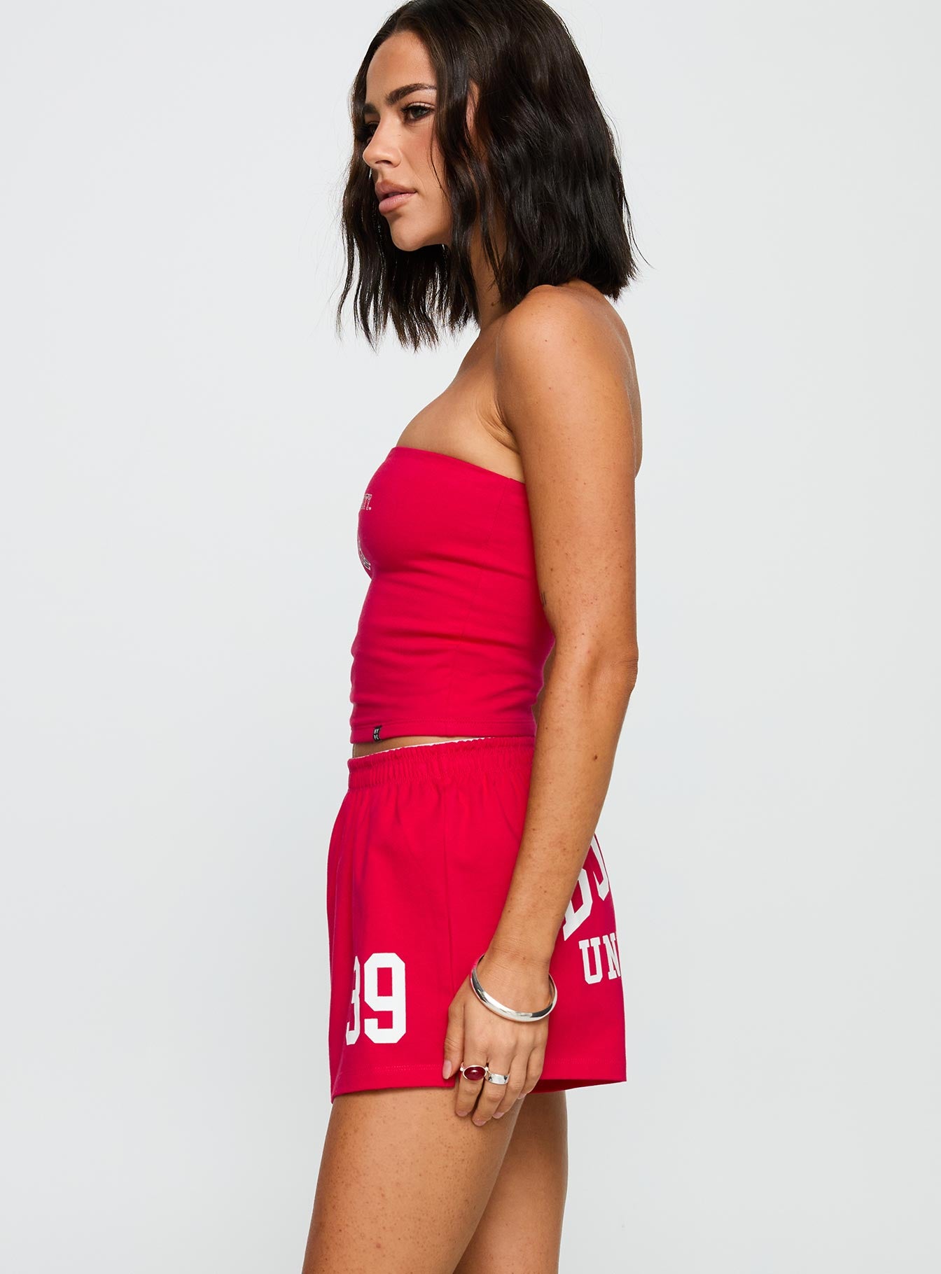 side view of model wearing Princess Polly Boston University Soffee Shorts Red High Waisted Shorts 