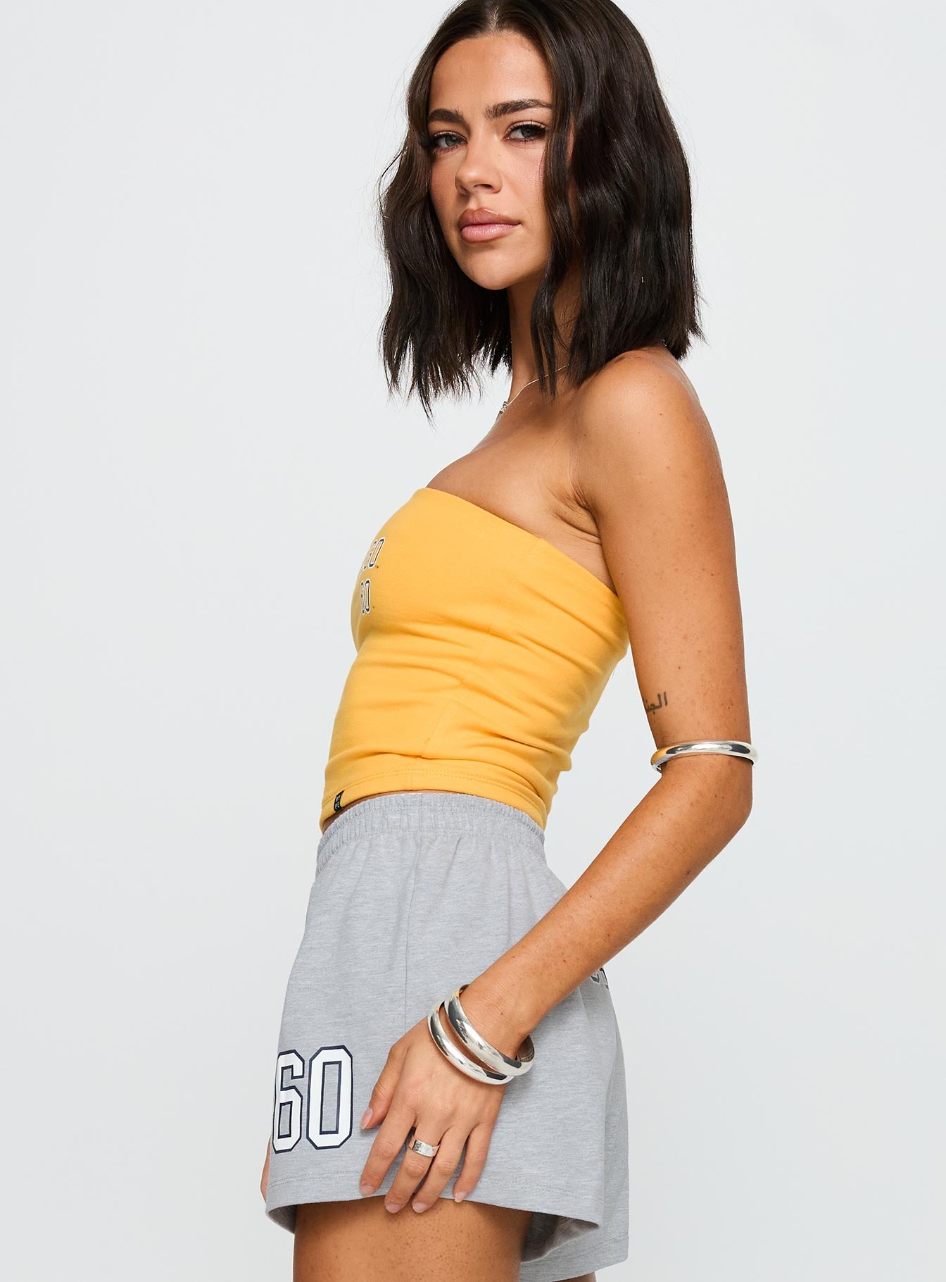 side view of model wearing Princess Polly UC San Diego Tube Top Gold Sleeveless straight 