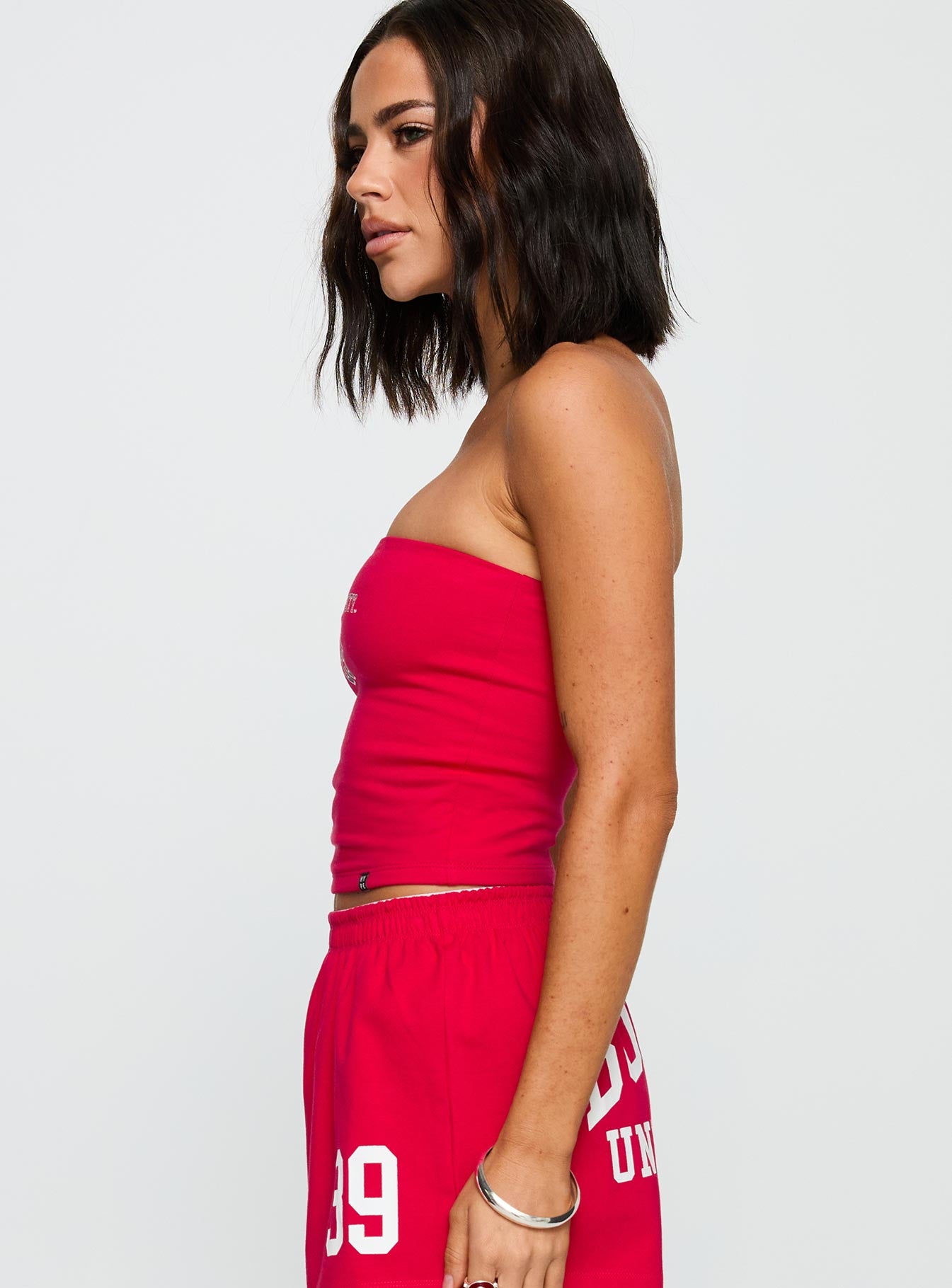 side view of model wearing Princess Polly Boston University Tube Top Red Sleeveless straight 