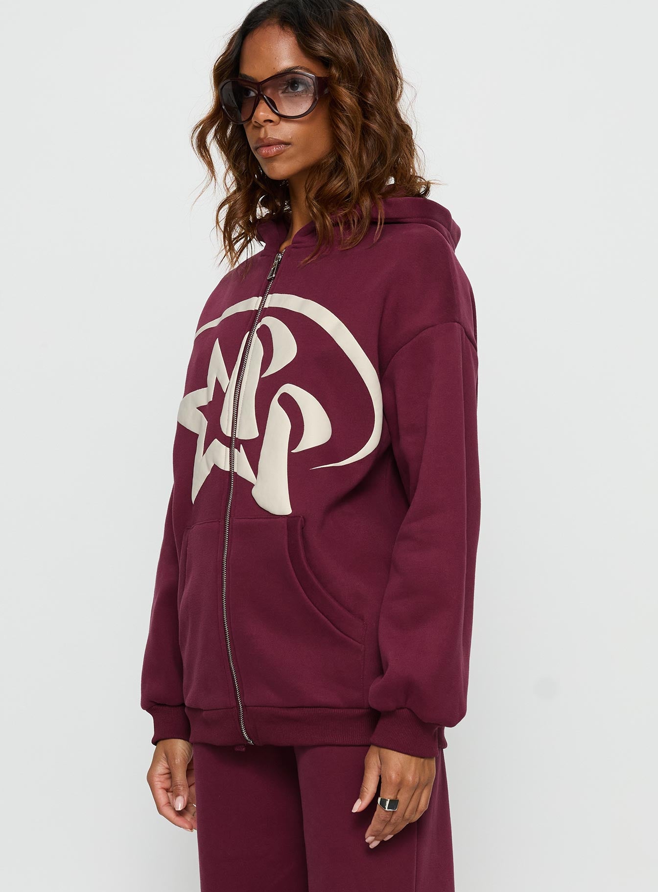 side view of model wearing Princess Polly Princess Polly Stargirl Zip Through Jumper Burgundy 