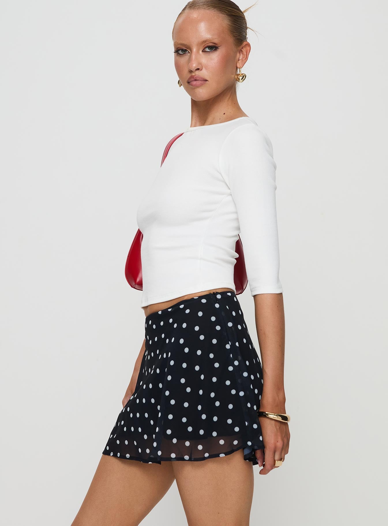   side view of model wearing Princess Polly Dapple Bias Mini Skirt Black Polka Dot Mini Skirts 