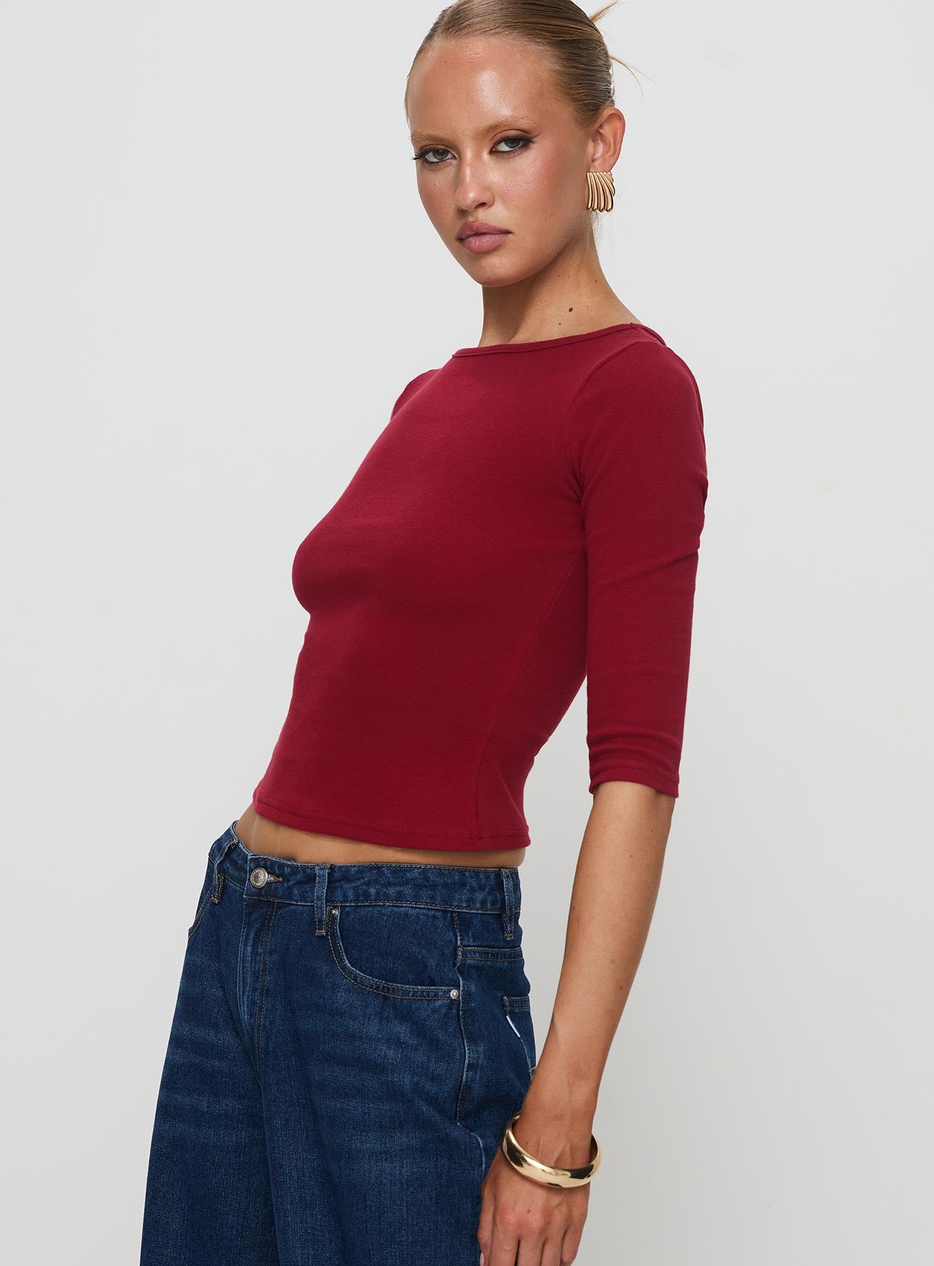 side view of model wearing Princess Polly Elaia 3/4 Sleeve Top Red Three Fourth Sleeves Crew Neck 