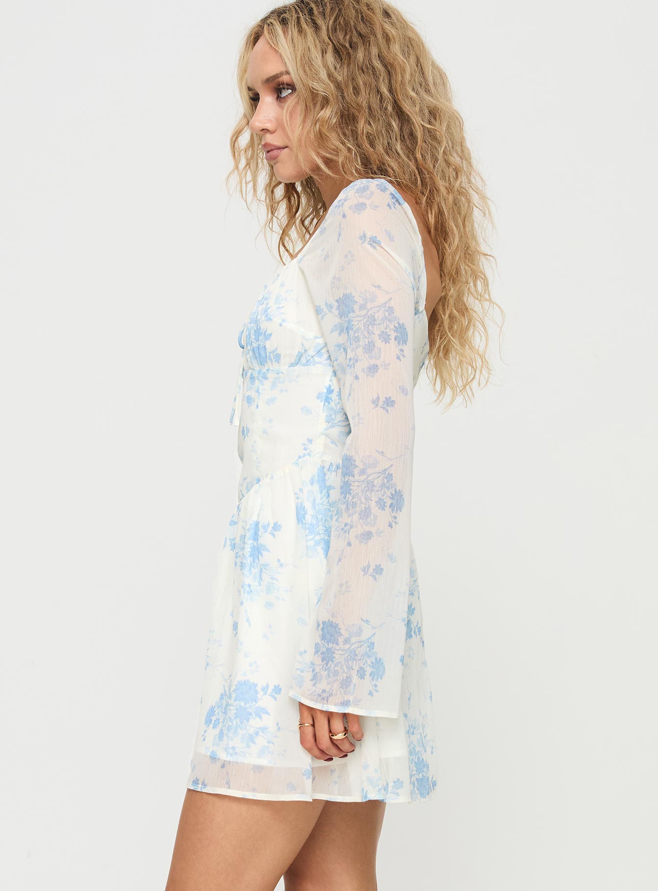 side view of model wearing Princess Polly Robertstone Long Sleeve Mini Dress White / Blue Floral Square Neck 
