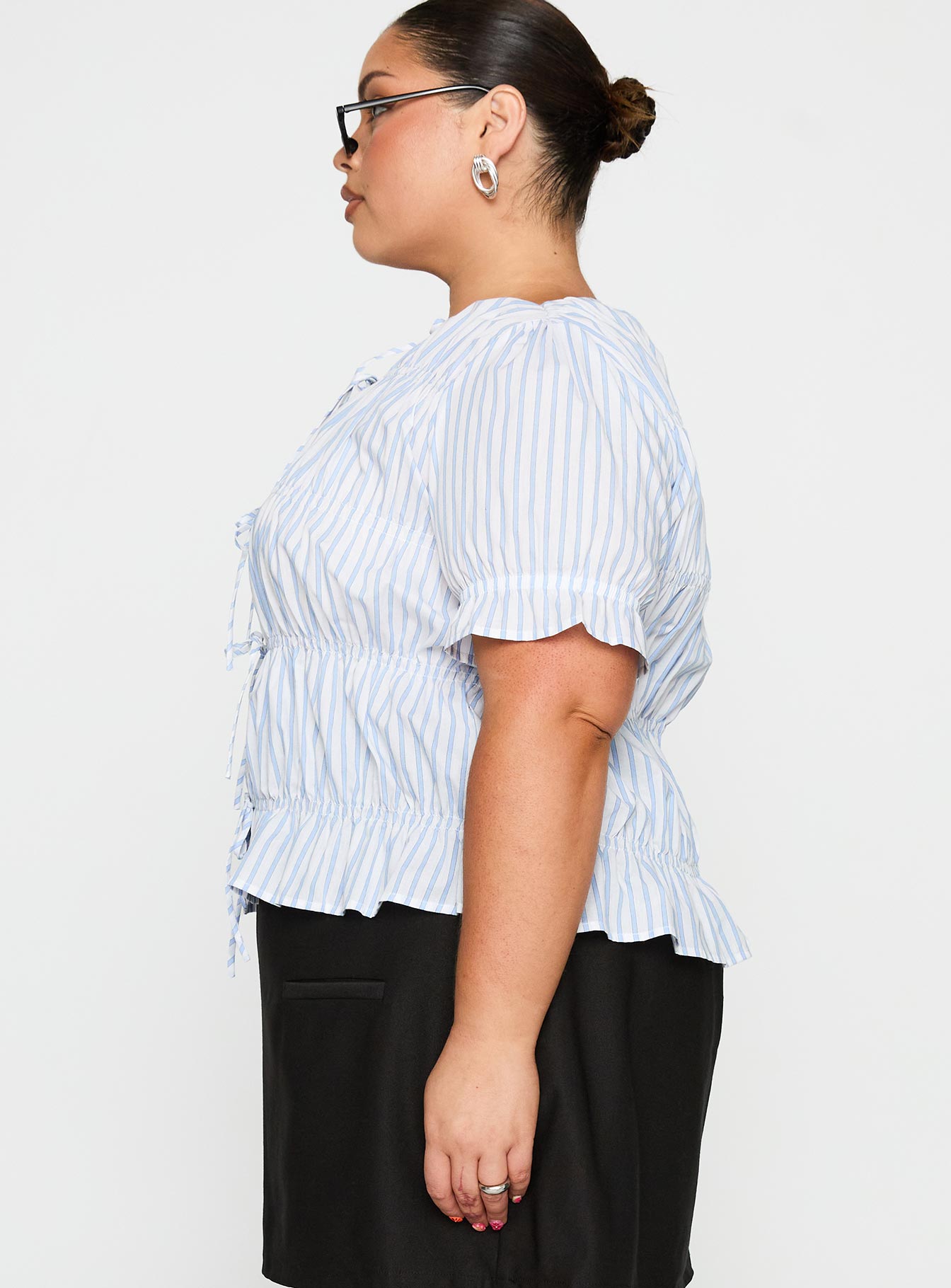 side view of model wearing Princess Polly Alistair Bow Tie Top Blue / White Stripe Curve Half Sleeves Crew Neck 