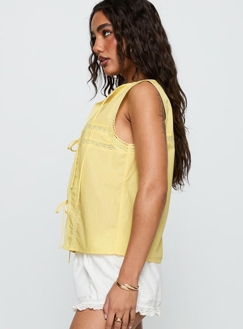 side view of model wearing Princess Polly Angourie Blouse Top Lemon Sleeveless Crew Neck 